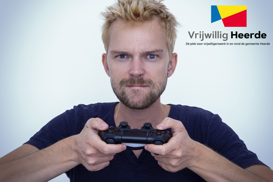 Een gezicht van een man, met een verbeten blik. Hij heeft een gamecontroller in zijn handen. Links bovenin staat het logo van Vrijwillig Heerde. Met de beschrijving: de plek voor vrijwilliogerswerk in en rond de gemeente Heerde.