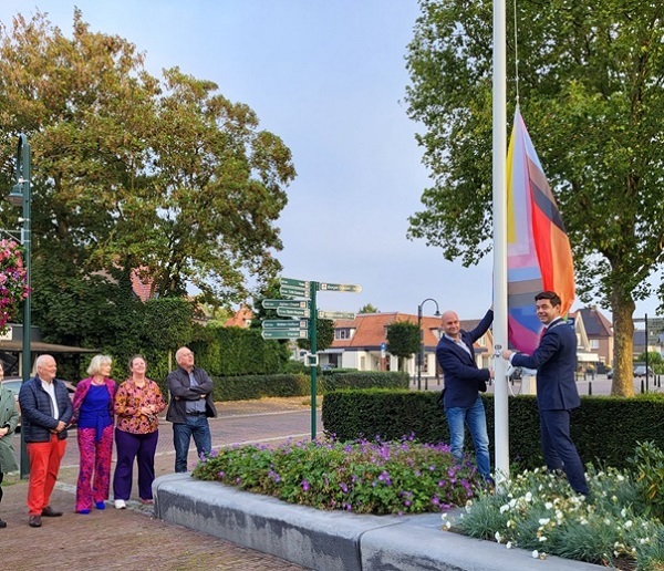 Wethouder William van Ommen en burgemeester Olaf Prinsen hijsen de regenboogvlag.